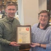 Jacob Yuill receives the award from Keighley and Craven CAMRA branch representative Jenny Baker