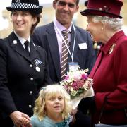 Lydia Beshenivsky presents flowers to the late Queen Elizabeth II as her dad, Paul Beshenivsky, and family liaison officer Cate Jackson look on