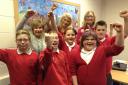 Cullingworth Village Primary School pupils celebrate the results with, from left, back, teaching assistant Mrs Jackie Ford, headteacher Mrs Kate Sutcliffe and teaching assistant Mrs Jane Dowd