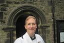 St Mary's Oxenhope priest in charge Reverend Nigel Wright outside the church
