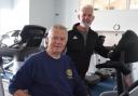 Ian Park, president of Haworth & Worth Valley Rotary Club, tries out a spinning bike at Workouts under the guidance of gym owner Paul Royston