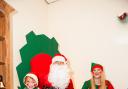 Santa Claus in his grotto in the Airedale shopping centre with elf Rachel Walmsley and one of his young fans