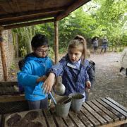 Children playing in the mud pie kitchen at East Riddlesden Hall, West Yorkshire. Picture by National Trust Images/Trevor Ray Hart