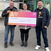 Jodie Hearnshaw – of Airedale Hospital and Community Charity – receives a cheque from Mike Burtoft, left, and Scott Goodwin