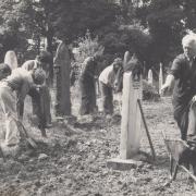 The Rev Hugh Cartwright, far right, vicar from 1978 to 1991, watches the churchyard being tended