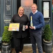 Kelly Gascoigne, of Haworth Steam Brewery, receives the award from Robbie Moore