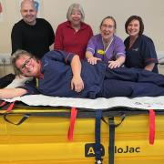 General surgery matron Anthea Wagstaff tries out the lifting device, with, from left, manual handling lead Matt Dickinson, Friends of Airedale chair Alison Dixon, orthopaedic nurse specialist Vicki Barlow and orthopaedics and endoscopy matron Vicki Egan