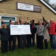 Members of the Italian Association of Keighley and Brian Langford, of Powell and Family Funeral Directors, celebrate the Festa event raising £2,000 for Manorlands Hospice