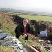 Keighley town councillor John Kirby with the items fly-tipped on Back Lane, Laycock