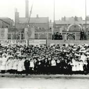 Sunday School children crowd along North Street to watch a procession commemorating the Coronation of King Edward VII