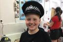 One of the pupils tries on a police hat for size at the school careers fair