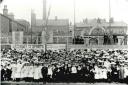 Sunday School children crowd along North Street to watch a procession commemorating the Coronation of King Edward VII