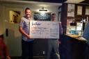 Manorlands fundraiser, Matthew Binns, collects the cheque from David Whitehead at Haworth Old Hall