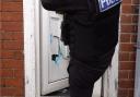 Police break down the door of a property during the County Lines operation