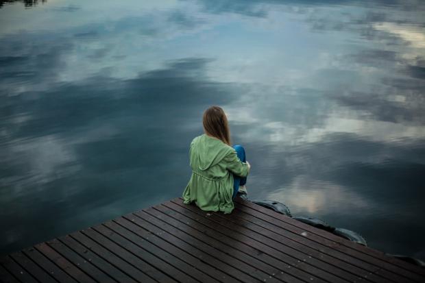 Keighley News: A woman looking out over the water. Credit: Canva
