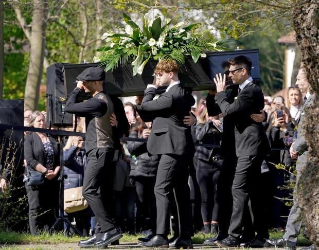 Keighley News: Max George (left) and Jay McGuiness of The Wanted (centre) carry the coffin at the funeral of their bandmate Tom Parker. (PA)