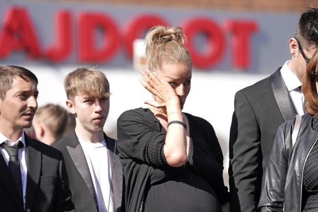 Keighley News: Mourners watch as the coffin of The Wanted star Tom Parker is carried ahead of his funeral. (PA)
