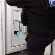 Police break down the door of a property during the County Lines operation