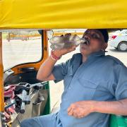 An auto-rickshaw driver drinks water as he takes a break in New Delhi, India (AP Photo/Shonal Ganguly)