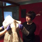 Principal Curator Ann Dinsdale carefully removes Charlotte Bronte's dress from display at the Bronte Parsonage Museum
