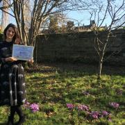 Emily Taylor, volunteer and community involvement manager at East Riddlesden Hall, in the hall’s garden with the award from Dementia Friendly Keighley