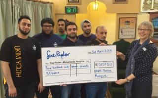 Manorlands hospice director Lizzie Procter receives a cheque from UKIM Madina Mosque members, from left, Idnan Amin, Amar Iqbal, Yassa Yaseen, Imran Iqbal, Sajid Ali and Nasser Iqbal